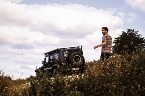 Homem com camisa estampada e Land Rover Defender preto em encosta, Recantos D'Almerinda, Pombal Portugal