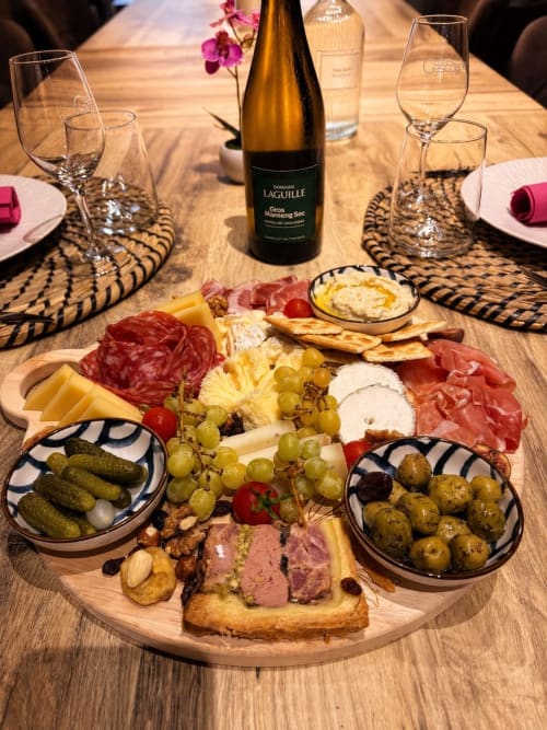 Plateau de charcuterie élégant au Gîte Le Jardin d'Elusa à Eauze avec vins, charcuteries, fromages et olives
