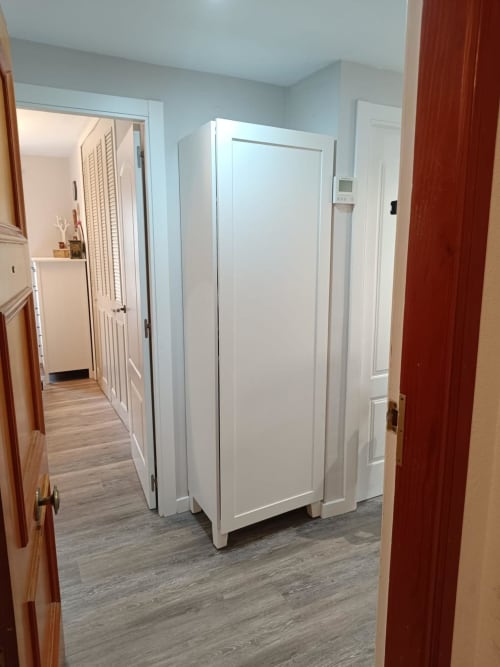 Modern hallway in Riviera Sunny Flat apartment with white wardrobe, wood flooring, and doorways to bedrooms at Mediterranea