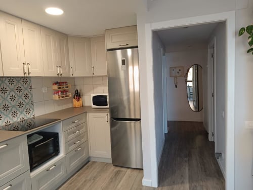 Modern kitchen in Riviera Sunny Flat apartment at Mediterranea Sunny Keys, Benicàssim with white cabinetry, stainless steel