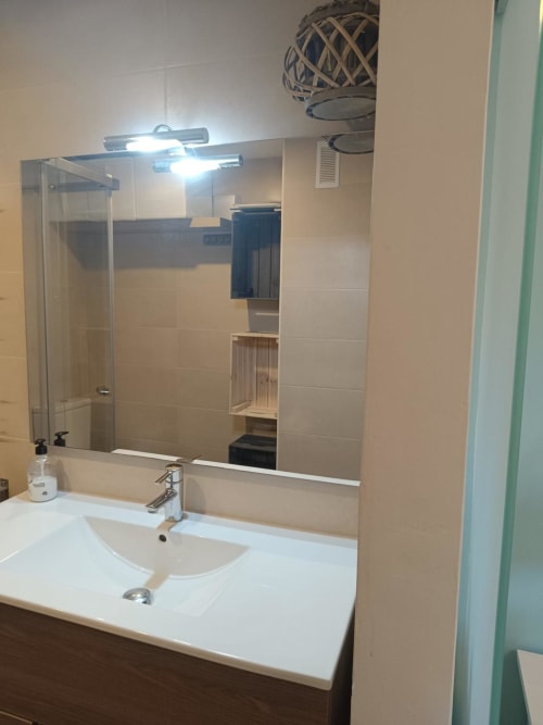 Modern bathroom vanity with white sink, mirror and LED lighting in Riviera Sunny Flat apartment at Mediterranea Sunny Keys,