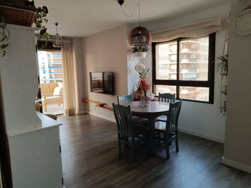 Modern apartment living area with dining table, TV, and sea views in Benicàssim's Riviera Sunny Flat