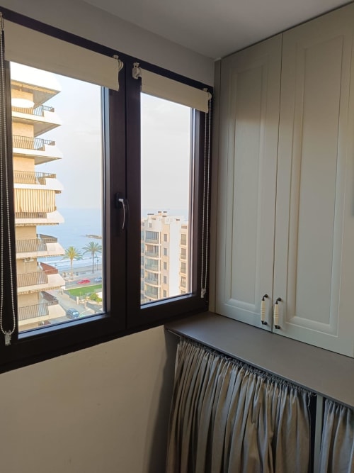 Modern apartment bedroom with black-framed windows overlooking Mediterranean Sea and Benicàssim coastline, contemporary