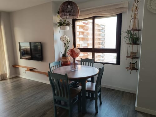 Modern dining area in Riviera Sunny Flat apartment with round table, sea views through large window, and city balcony