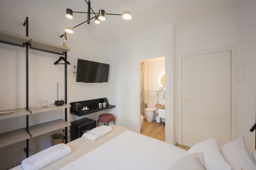 Camera moderna di Manu Maison a Parma con TV a parete, zona scrivania minimalista e bagno privato