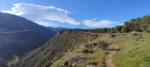 Paisaje montañoso con vistas al valle y bosque de pinos cerca de la Hospedería Puerta a los Cahorros en Monachil
