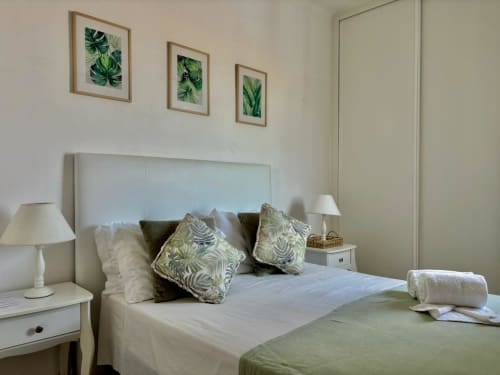 Quarto brilhante no hotel Al Mare Ocean View em Albufeira com cama moderna, arte botânica, luminárias de cabeceira e toalhas dobradas