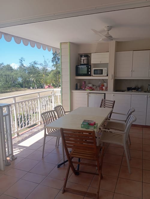Balcon avec coin repas, vue mer, kitchenette et jardin aux Tropic Appartements à Sainte-Anne