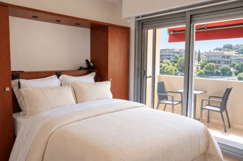 Modern double bedroom at La Joya hotel in Cavalaire-sur-Mer with city view balcony and contemporary furnishings