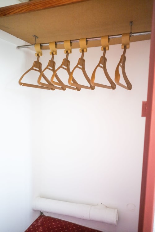 Cintres en bois sur une tringle dans le placard d'une chambre d'hôtel à La Joya, Cavalaire-sur-Mer