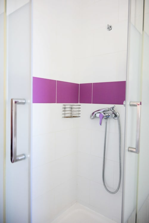 Salle de bain moderne avec panneaux violets et robinetterie chromée à l'hôtel La Joya à Cavalaire-sur-Mer