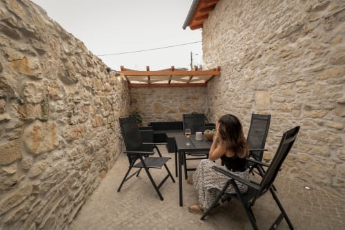 Mulher jantando no pátio de pedra do hotel Recantos D'Almerinda em Pombal, Portugal