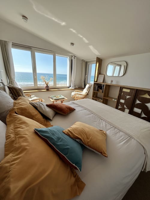 Chambre lumineuse avec vue mer à La Villa Plein Vent, lit, chaises longues et océan à Barneville-Carteret
