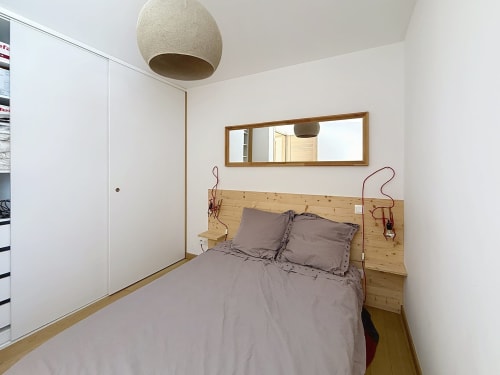 Chambre douillette avec lit en bois et literie grise aux Tanières de Montgenèvre, Montgenèvre
