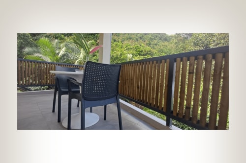 Rooftop balcony at Joubarbe Résidence in Moka with mountain views, modern seating, and lush vegetation