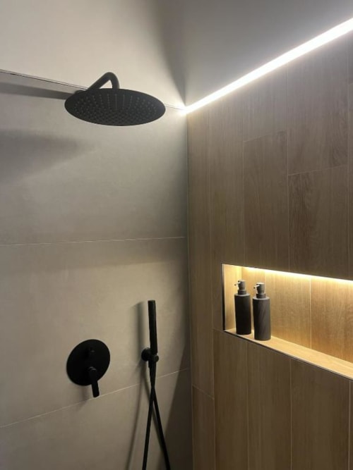 Doccia moderna nelle Marelia Suites Vasto con soffione pioggia nero, finiture minimaliste e illuminazione ambientale