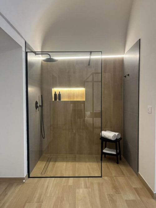 Moderna cabina doccia con cornice nera e pannelli in vetro presso Marelia Suites a Vasto, Italia