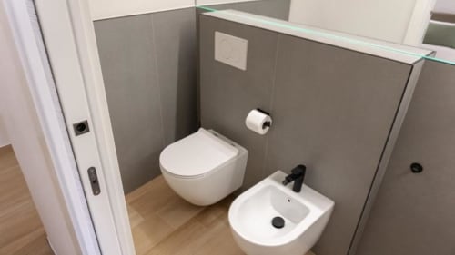 Bagno moderno della camera doppia 102 presso Marelia Suites B&B a Vasto, con toilette bianca, bidet e pareti in piastrelle grigie