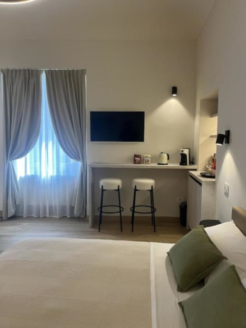 Camera moderna presso Marelia Suites a Vasto con scrivania, TV, angolo bar e luce naturale dalla finestra