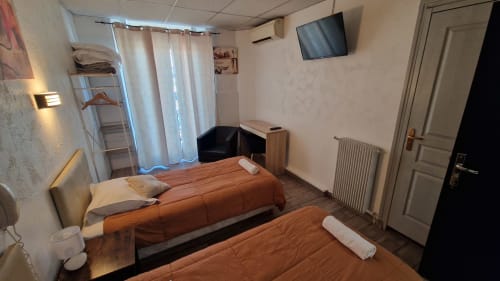 Chambre avec lits jumeaux à l'Hôtel Du Nord Cannes, TV, radiateur et accès balcon vue ville