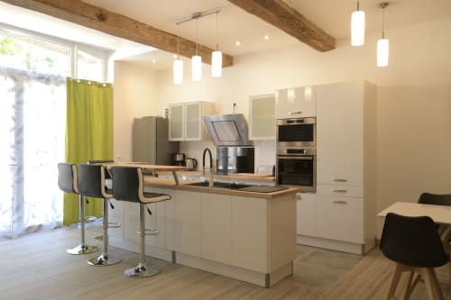 Moderne Küche mit weißen Schränken, Holzarbeitsplatten und Frühstückstheke im Ferienhaus Domaine Le Piboul in Fontcouverte,
