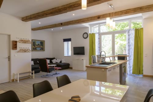 Moderner offener Cottage-Innenraum im Domaine Le Piboul mit Essbereich, Küche und Lounge mit Balkendecken