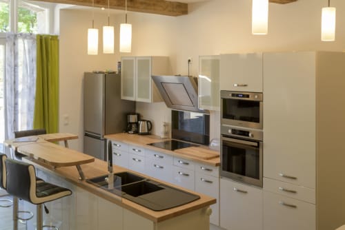 Moderne Küche mit Holzarbeitsplatten, Edelstahlgeräten und Speiseinsel im La Grange Cottage des Domaine Le Piboul