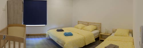 Schlafzimmer La Grange im Domaine Le Piboul mit Einzelbetten, gelber Bettwäsche, TV und Holzmöbeln in Fontcouverte