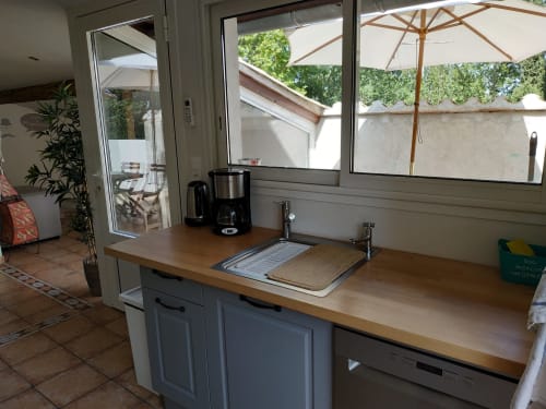 Küchenbereich im Cottage Les Cuves auf Domaine Le Piboul mit Gartenblick durch große Fenster und Terrassenschirme