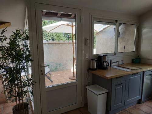 Küchenbereich im Cottage Les Cuves auf Domaine Le Piboul mit Gartenblick durch Glastüren und Terrasse