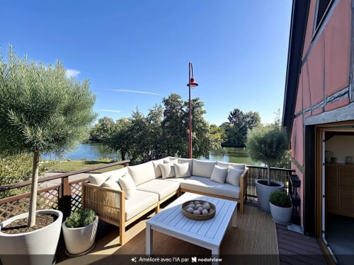 Terrasse bord de l'eau à A L'ill Apart à La Wantzenau avec salon, foyer et vue sur la rivière
