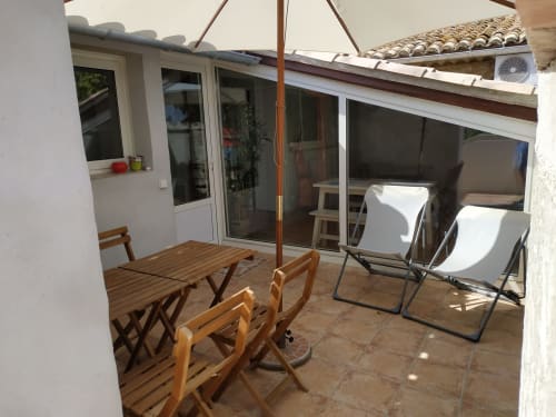 Terrasse mit Holzesstisch, Stühlen, Sonnenschirm und Loungebereich im Cottage Domaine Le Piboul in Fontcouverte