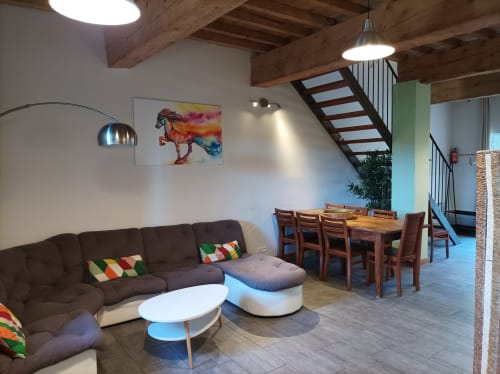 Gemütliches Wohnzimmer mit braunem Sofa, Esstisch und freigelegten Holzbalken im Domaine Le Piboul, Fontcouverte