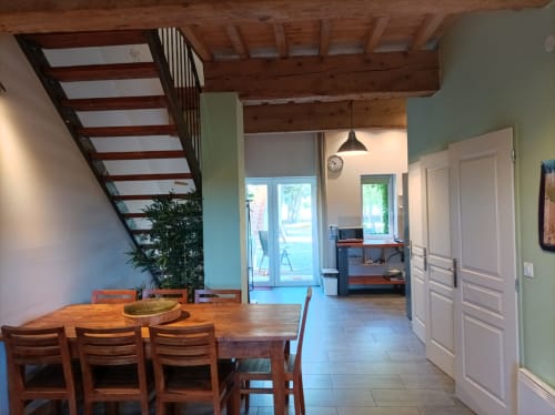 Geräumiger Wohn- und Essbereich im Ferienhaus Les Ecuries in Fontcouverte mit Holzbalken, Esstisch und Türen mit Gartenblick