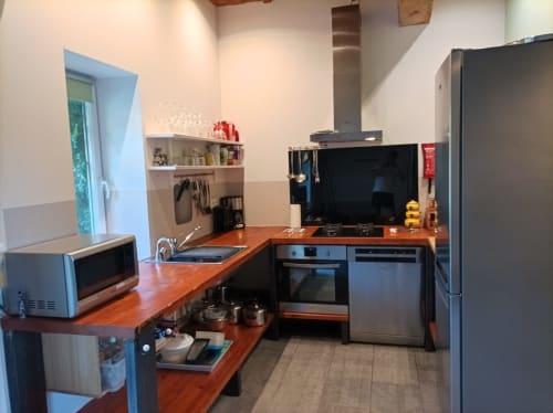 Moderne Küche mit Holzarbeitsplatten, Edelstahlgeräten und Essbereich im Ferienhaus Les Écuries von Domaine Le Piboul