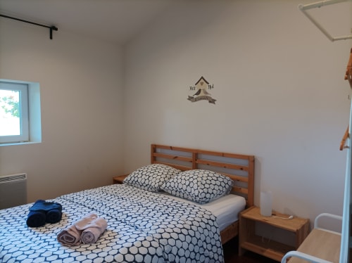 Schlafzimmer mit Holzbett, blauem gemustertem Bettzeug und aufgerollten Handtüchern im Cottage Domaine Le Piboul in Fontcouverte