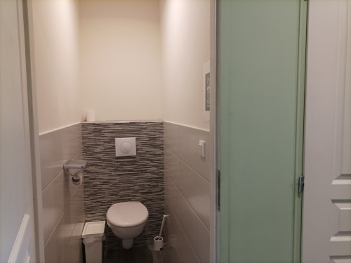 Modernes Badezimmer im Ferienhaus Domaine Le Piboul mit gestreifter Fliesenakzentwand und weißen Armaturen