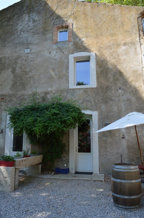 Eingang Le Régisseur im Domaine Le Piboul, Fontcouverte, mit efeubedeckten Mauern und Gartenhof
