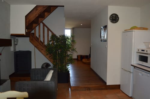 Offene Küche und Wohnbereich im Landhaus Domaine Le Piboul mit Holztreppe, Essbereich und modernen Geräten