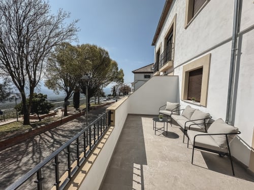 Terraza soleada de Apartamentos Estrella Baeza con tumbonas con vistas al paisaje de Baeza