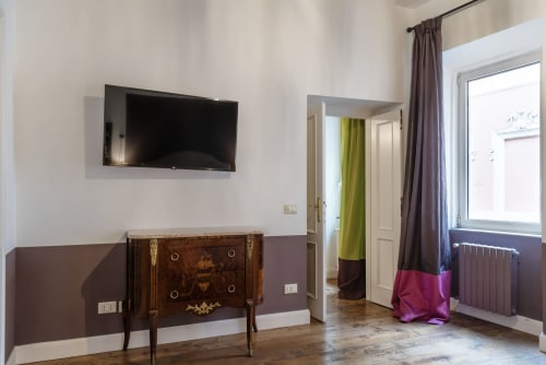 Appartamento moderno a Residenze Clodio vicino alla Scalinata di Spagna a Roma, con TV a parete, antico comò e arredi colorati