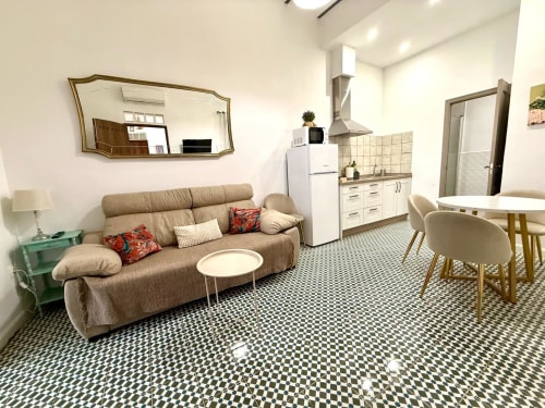 Moderno apartamento Deluxe en Casa Turística San Agustín en Córdoba con sofá beige, cocina, comedor y azulejos con patrón