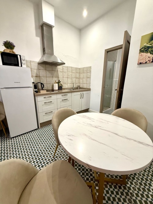 Cocina y comedor modernos en el apartamento Deluxe de Casa Turística San Agustín, Córdoba con muebles blancos y mármol