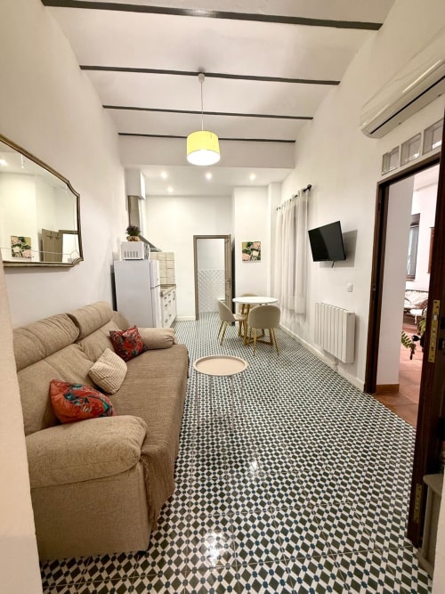 Salón moderno del apartamento deluxe Casa Turística San Agustín, Córdoba, con sofá beige, piso de azulejos geométricos y