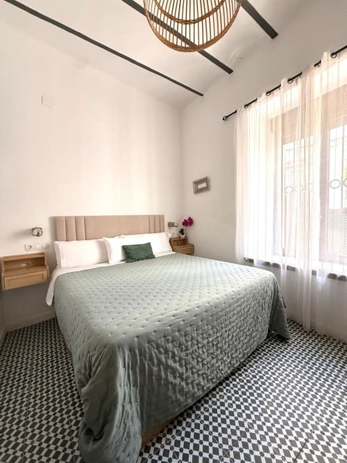 Habitación moderna en Casa Turística San Agustín de Córdoba con cama queen, cabecero beige, vistas al jardín y decoración en blanco y negro