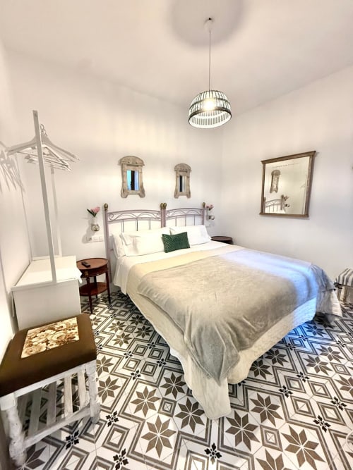Habitación de apartamento deluxe en Casa Turística San Agustín, Córdoba con cama de metal, piso con patrones, luz colgante y jardín