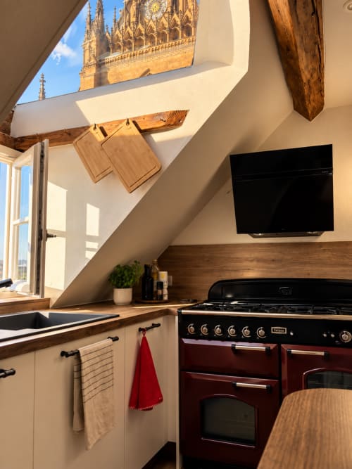 Modern kitchen with red range cooker, cathedral view through skylight in Metz apartment