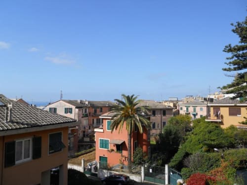 Edifici mediterranei colorati dell'Hotel Villa Moderna a Genova, con vista sul mare e rigogliosa vegetazione