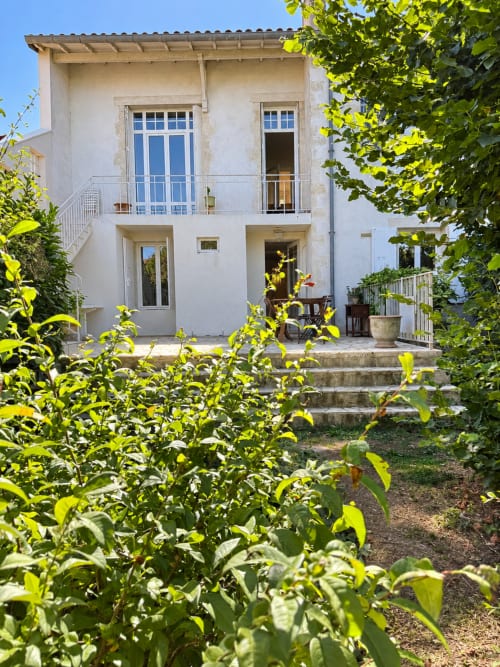 Villa blanche aux volets bleus entourée d'un jardin verdoyant, La Rochelle