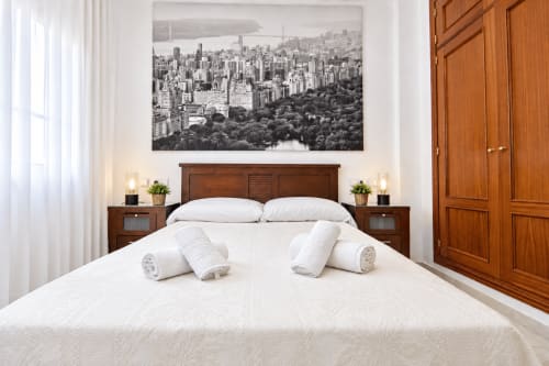 Suite Castelar del hotel Living Sur en Sanlúcar de Barrameda con moderno dormitorio, toallas enrolladas y cabecero de madera